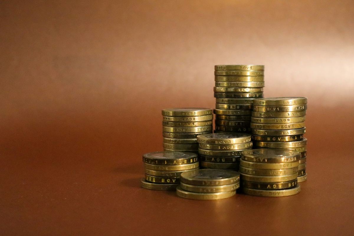 Tumpukan koin emas dengan jam meja